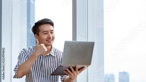 Asian Businessman Using Laptop in Modern Office, Online Work, Technology and Business Success