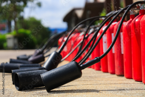Red tank of fire extinguisher are lined up and ready for use during fire-fighting training, safety week, fire prevention, loss prevention.
