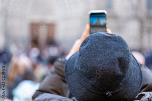 Tourist capturing famous cathedral landmark with a smartphone while traveling