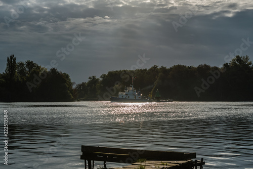 MARITIME TRANSPORT - A small auxiliary vessel is sailing through a channel with a navigation buoy on board
