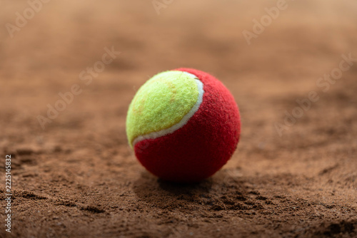 Red and Yellow Tennis Ball on Clay Court Close-Up