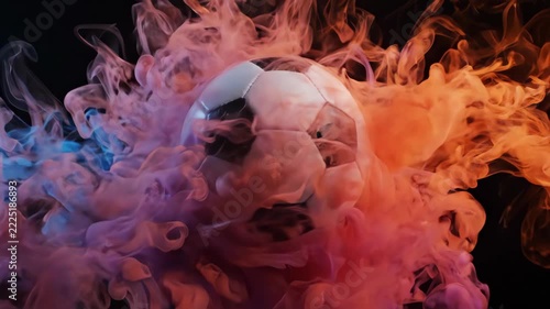 Vibrant orange, pink, and blue ink swirling dynamically in water on a dark background.