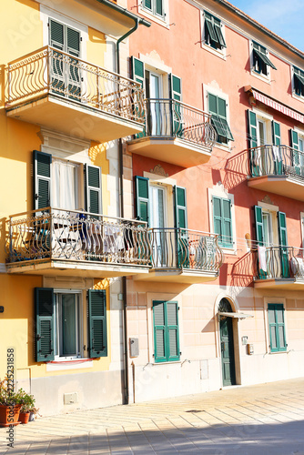 Ligurian architecture facades balconies Italy. Pastel colors heritage preservation city lifestyle. Mediterranean travel destination real estate guide.