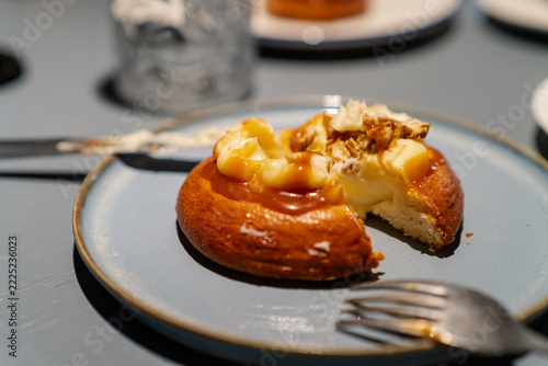 Sweet cream bun dessert with caramel sauce and walnuts on plate
