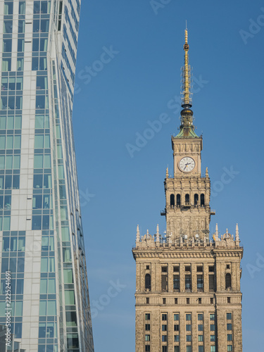 Palace of Culture and Science in Warsaw, Poland stands in sharp architectural contrast next to a modern curved glass skyscraper