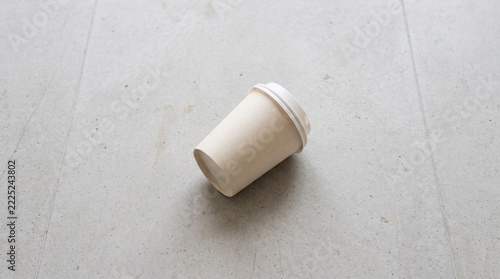 Blank paper coffee cup mockup for branding design on a neutral grey