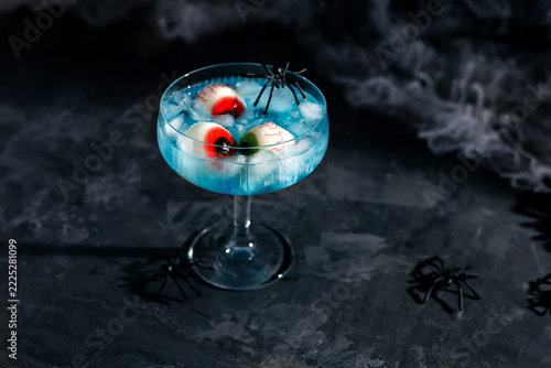 Halloween blue cocktail with spooky eyeball candy and spiders