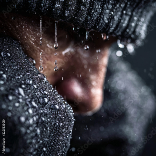Close-up of athletic man in beanie dripping with water after intense workout
