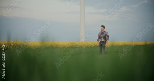 Young man standing in a yellow flower field