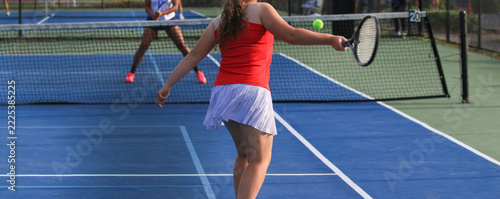 Tennis Match in Progress With Female Players on Blue Court Surface