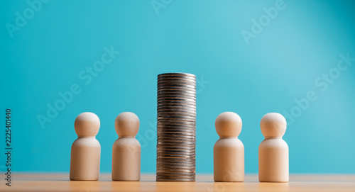 Team financial success and money division concept with wooden figures and coin stack