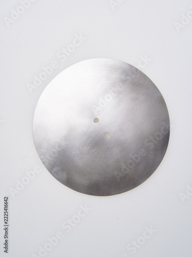 Polished round steel rondel plate on a clean white background, showing its smooth texture and central mounting holes.