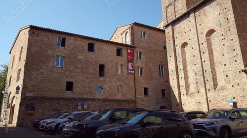  arched windows under a clear blue sky in Urbino, Italy.