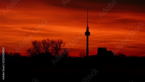 Berlin TV tower silhouette against a dramatic vibrant red sunset sky in January, Germany