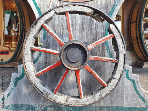 Wooden wheel as decoration for a shop on a city street.