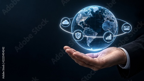 Businessman holding glowing digital earth globe with technology and communication icons symbolizing global connectivity and networking