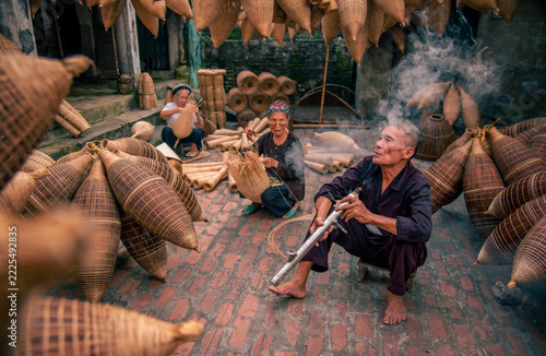 Obraz na plátně Vietnamese fishermen are doing basketry for fishing equipment at morning in Thu Sy Village, Vietnam