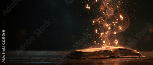 Open book with glowing magical symbols and sparks rising from pages