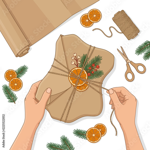 Overhead View of Hands Wrapping a Christmas Gift with Natural Decorations and Dried Orange Slices