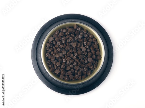 Metal bow with granulated  Pet food.  High angle view, isolated on white. 