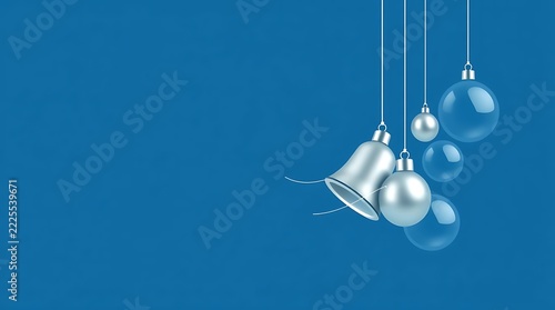Silver Christmas ornaments and bell hanging against a blue background with soft focus and copy space