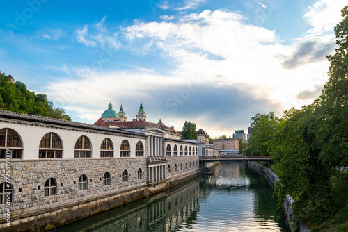 Scenic city view of Ljubljana Central Market by the Ljubljanica river with St. Nicholas Cathedral towers and Butchers bridge in Slovenia