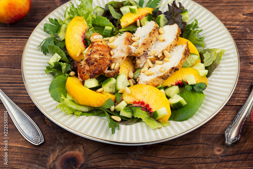 Fresh green salad with roasted chicken, peach and pine nuts