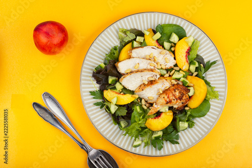 Fresh green salad with roasted chicken, peach and pine nuts