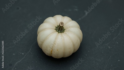 A small white pumpkin sitting on a table