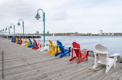 A Row of Colorful Adirondack Chairs on the Boardwalk of Halifax Harbourfront Facing Dartmouth