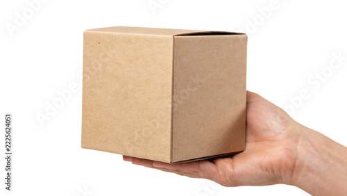 Hand holding a closed cardboard box with soft diffused lighting against a void for shipping and delivery concepts