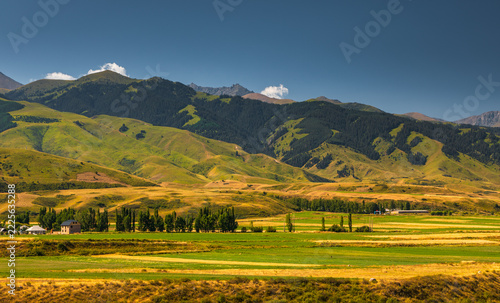 Kyrgyzstan mountain valley with rural landscape and farm fields