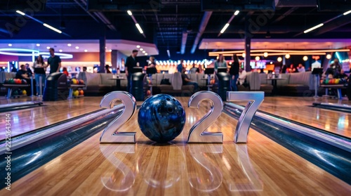 Chrome 2027 numerals positioned on a glowing bowling lane, presenting a modern New Year sports and entertainment concept with nightlife atmosphere and copy space