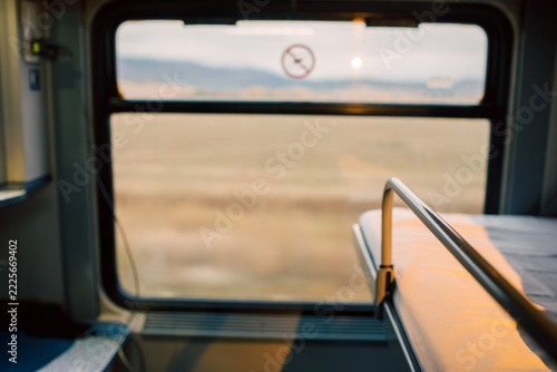 Fotografie Sleeper train compartment interior with big window and lower bunk with rail and