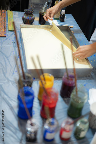 Artist Lifting Paper from Water Marbling Tray During Traditional Turkish Ebru Workshop