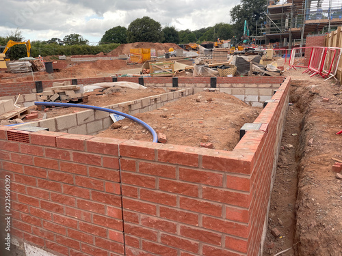 New brick foundation walls take shape amid materials at an active construction site