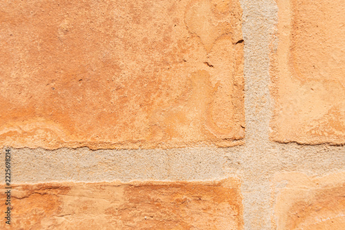 Terracotta clay tiles forming a textured surface with sandy grout lines