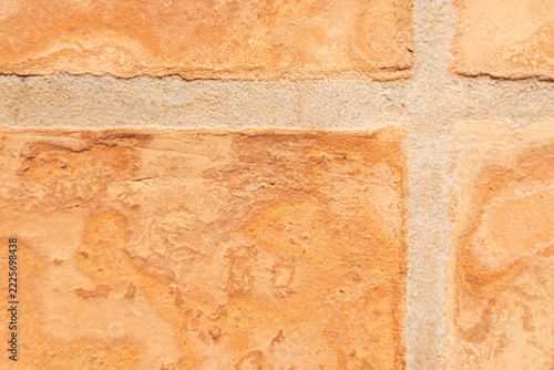 Terracotta clay tiles forming a textured surface with sandy grout lines