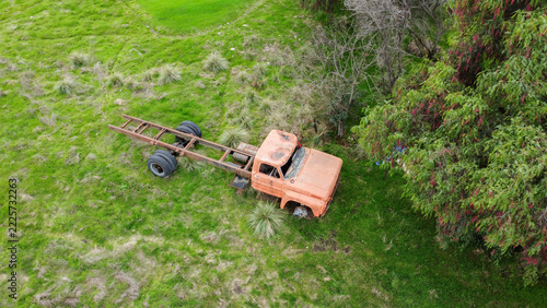 Aerial View of an Old Rusty Abandoned Truck in a Green Field Surrounded by Trees