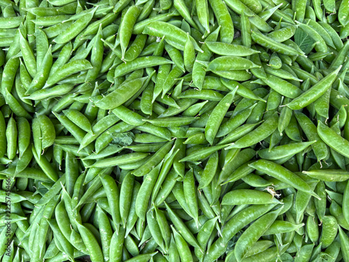 Pile of fresh snap peas at a market stand