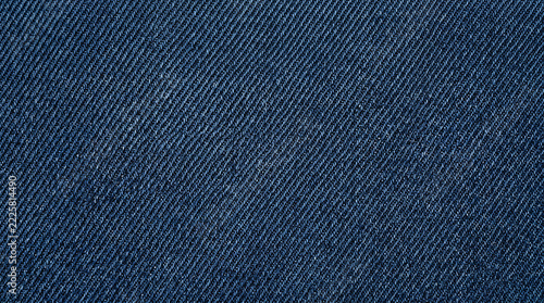 Close up view of dark blue denim fabric texture showing the woven cotton twill pattern details