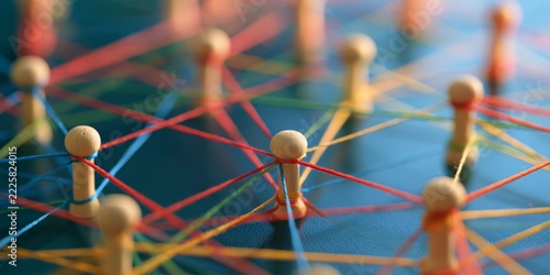 Colorful network of wooden pins with red, blue, green, yellow, and orange strings creating a complex connected web for visual representation of communication and connecti