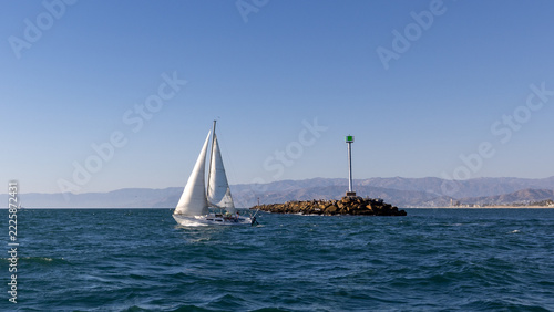 Sailboat Passing Channel Islands Harbor Jetty in Port Hueneme California