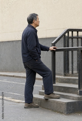 Mature man stepping onto an outdoor stair beside a handrail