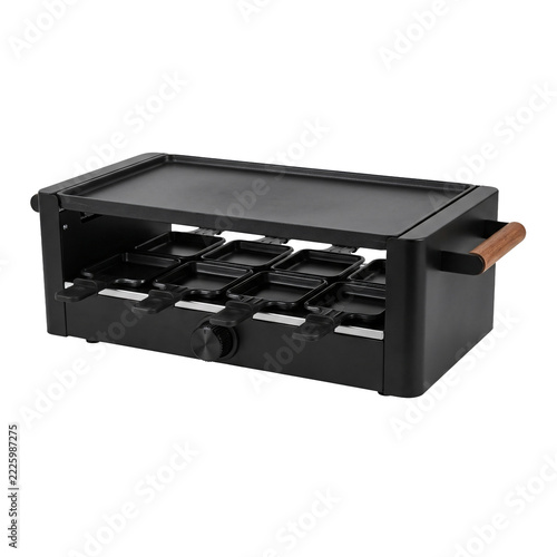 Black tabletop raclette grill with a flat top griddle plate, a row of small cheese pans underneath, a dial and a wooden side handle, isolated on transparent background