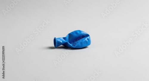 A single deflated blue balloon isolated on a clean white background