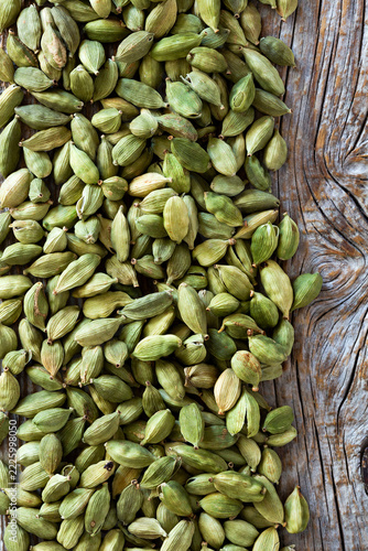 Close-up of green cardamom pods on rustic wooden surface