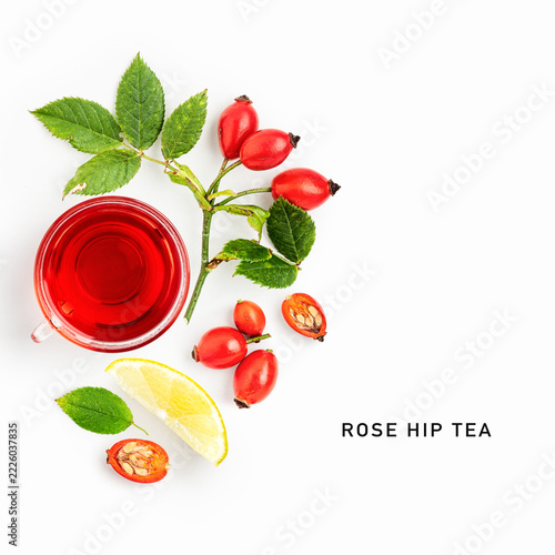 Rose hip tea with fresh rose hips and lemon isolated on white background. Natural ingredients for warming herbal drink and seasonal nutrition