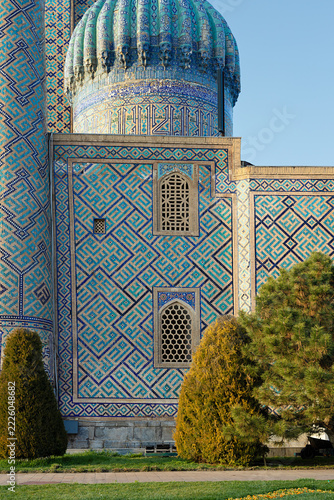 Sher-Dor Madrasah facade detail at Registan Square in Samarkand showing intricate geometric tilework and ribbed dome. Ideal for travel guides, cultural publications, and architectural references.