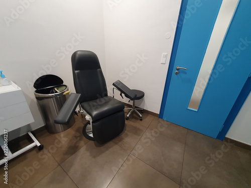 Medical Examination Chair in Clinic With Blue Door and Arm Rests for Patient Treatment